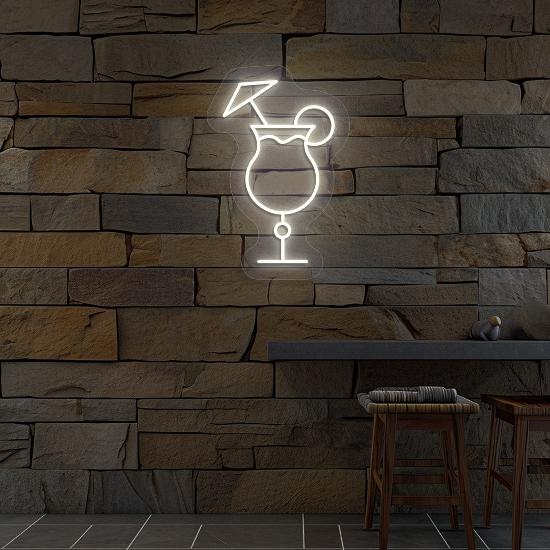 Stylish "cocktail glass with a lime" neon sign glowing warm white on wall.