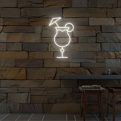 Stylish "cocktail glass with a lime" neon sign glowing warm white on wall.