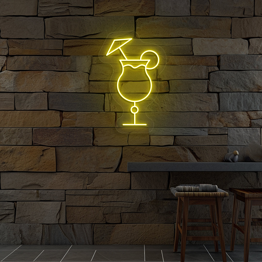 Stylish "cocktail glass with a lime" neon sign glowing yellow on wall.