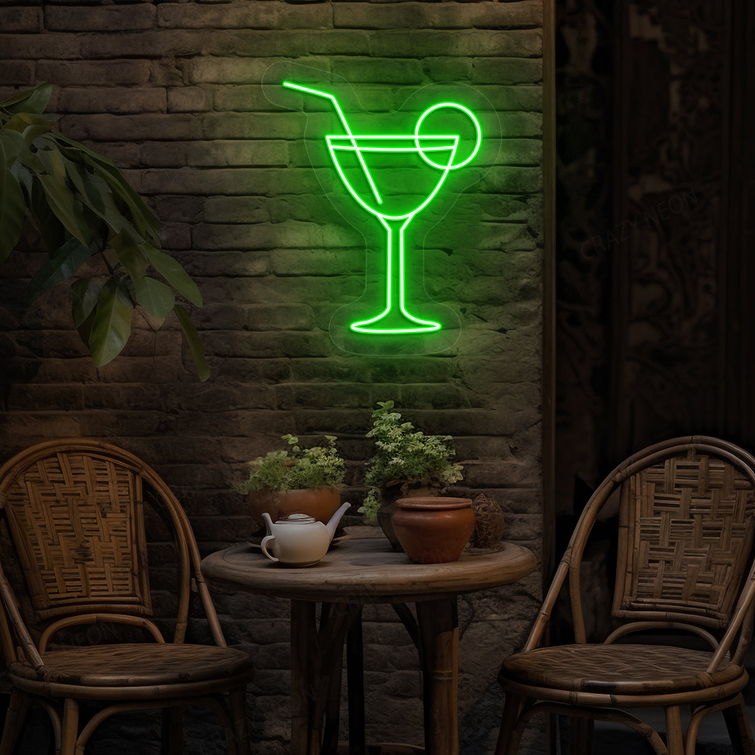 Stylish cocktail neon sign glowing green on bar wall.