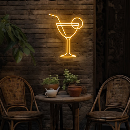 Stylish cocktail neon sign glowing orange on bar wall.