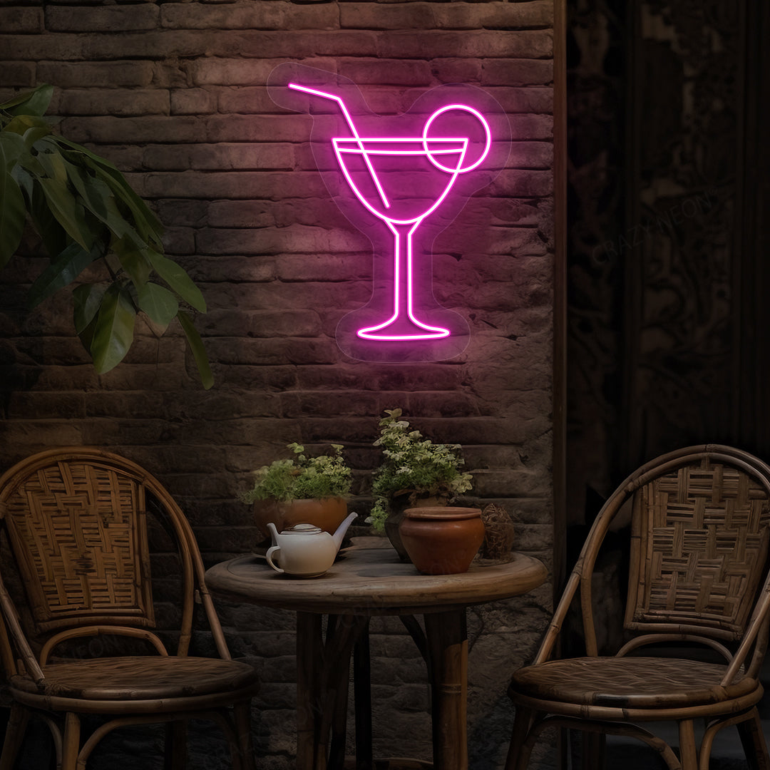 Image of a cocktail LED neon sign glowing on a bar wall in pink color.