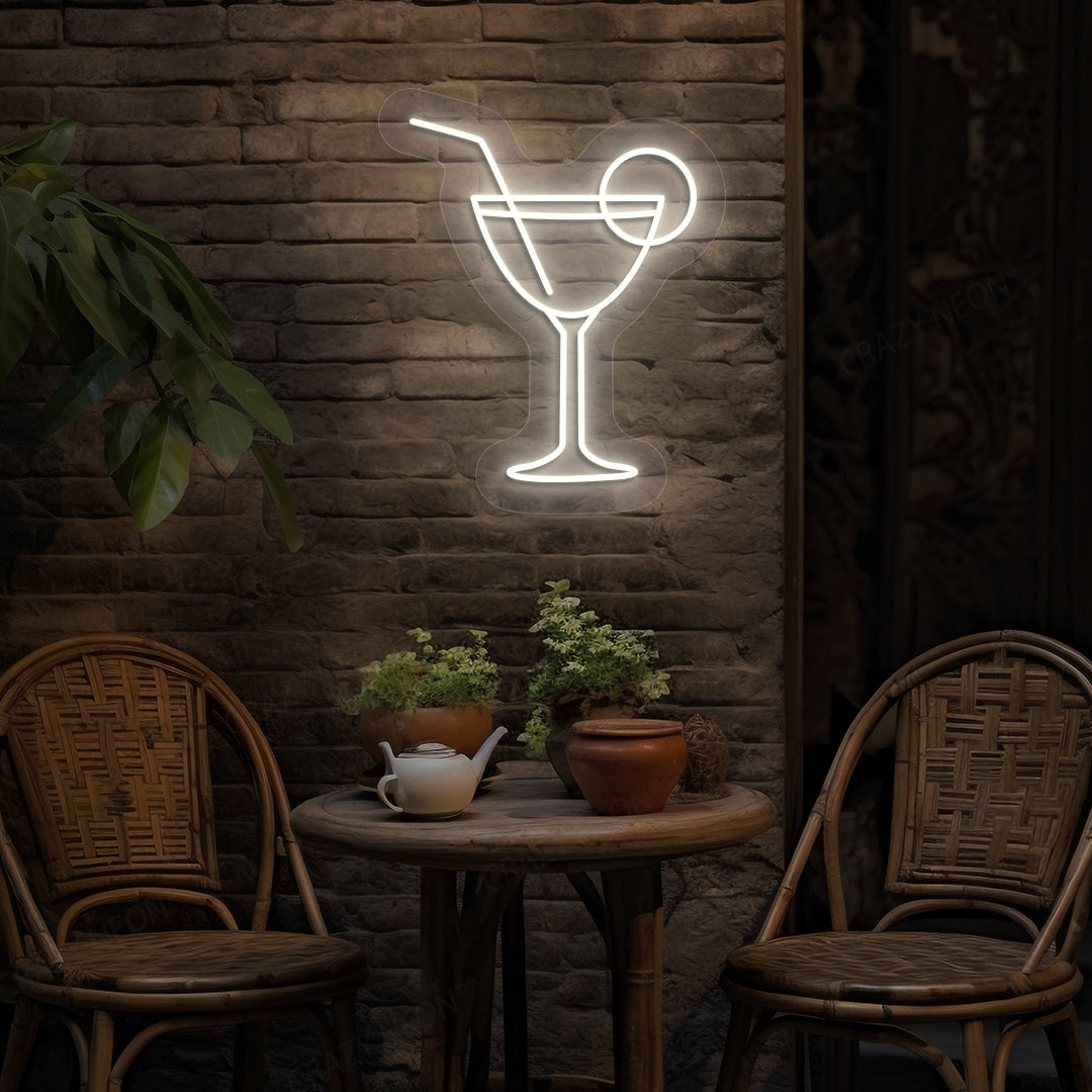 Stylish cocktail neon sign glowing warm white on bar wall.