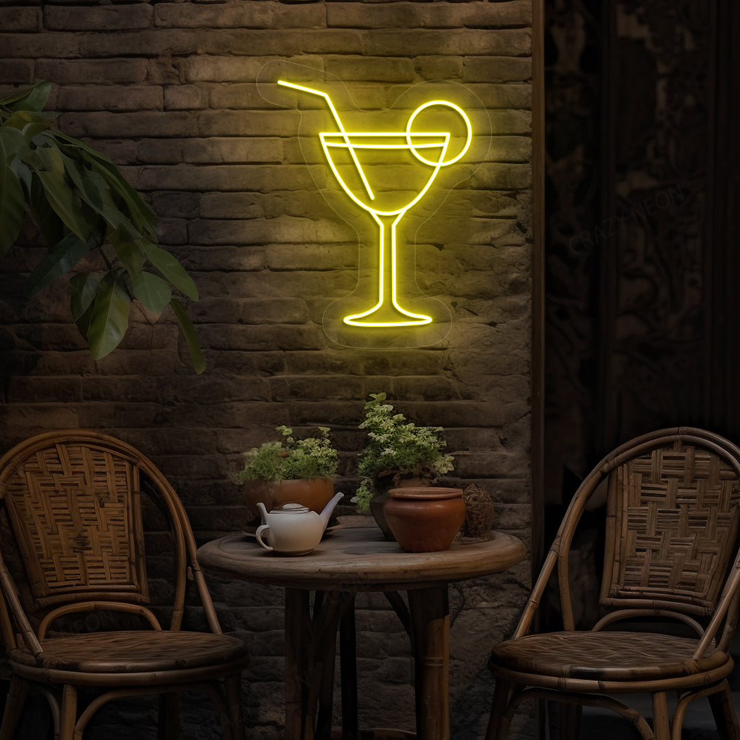 Stylish cocktail neon sign glowing yellow on bar wall.