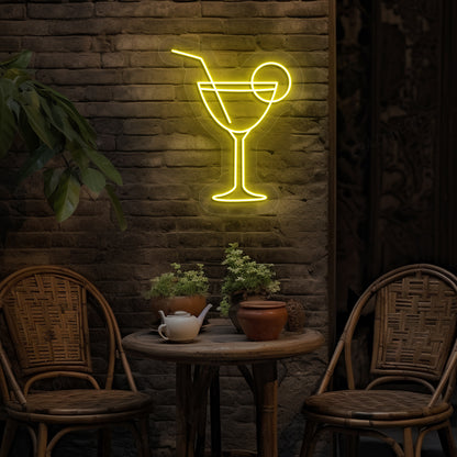 Stylish cocktail neon sign glowing yellow on bar wall.