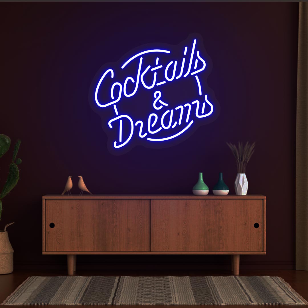 Image of a cocktail and dreams neon sign mounted on a bar wall in blue color.