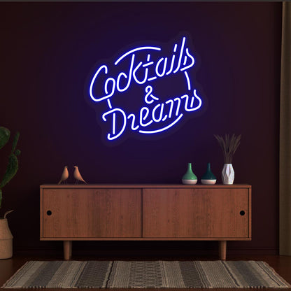 Image of a cocktail and dreams neon sign mounted on a bar wall in blue color.