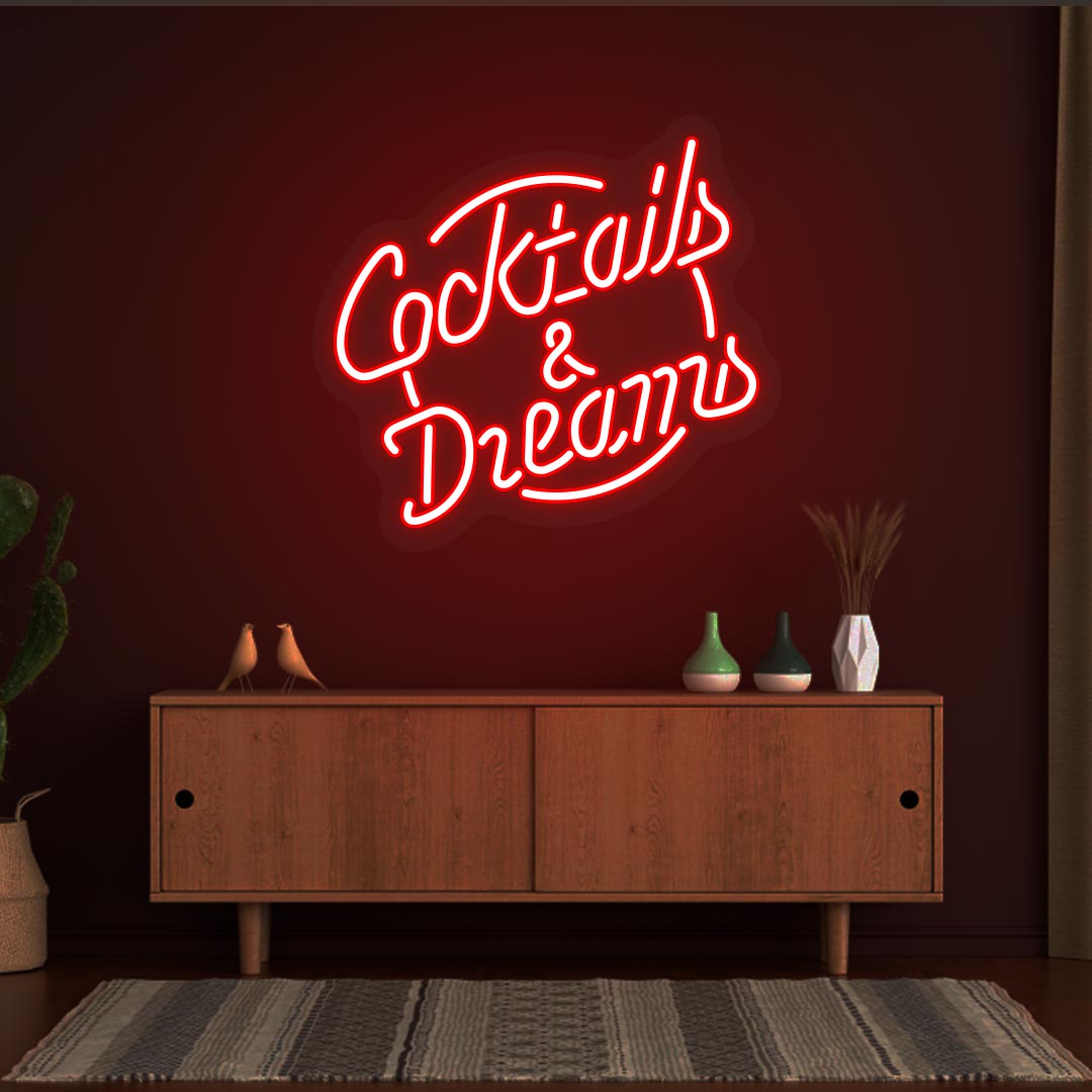 Decorative cocktail and dreams LED neon sign glowing red on the wall.