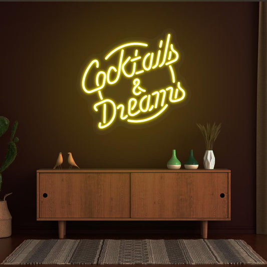 Image of a cocktail and dreams neon sign mounted on a bar wall in yellow color.