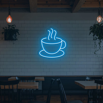 A bright ice blue LED coffee mug neon sign is mounted on the cafe wall. Perfect for coffee shops, bakeries, home coffee corners, and restaurants.