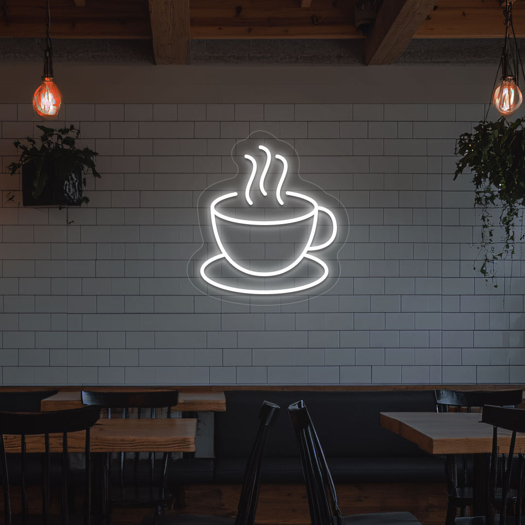 Image of a coffee mug neon sign mounted on a cafe wall in warm white color.