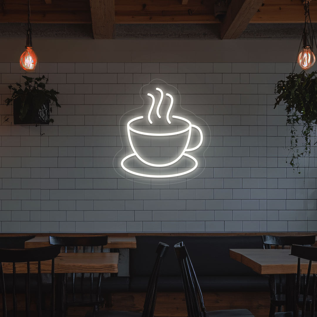 A bright white LED coffee mug neon sign is mounted on the cafe wall. Perfect for coffee shops, bakeries, home coffee corners, and restaurants.
