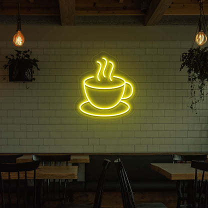 Image of a coffee mug neon sign mounted on a cafe wall in yellow color.