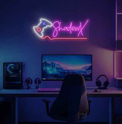 Personalized gamer name neon sign with controller mounted on decorative wall in pink color.