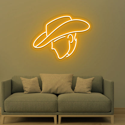 Image of a cowboy face neon sign glowing on a living room wall in orange color.