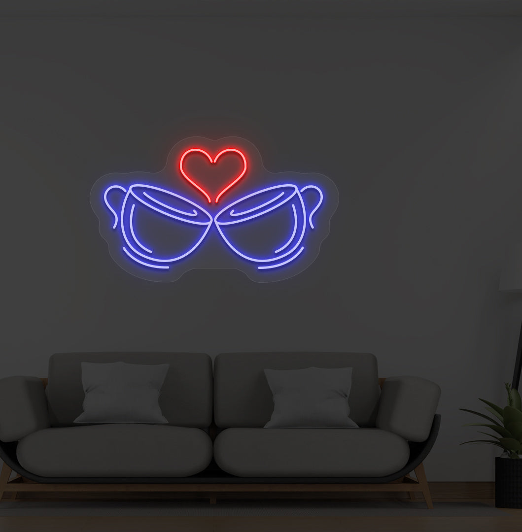 Image of stylish cup heart LED neon sign glowing blue on wall.
