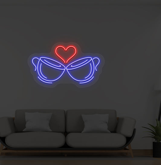 Image of stylish cup heart LED neon sign glowing blue on wall.