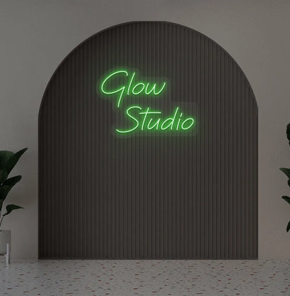 Stylish personalized business name neon sign mounted on aesthetic wall in green color.