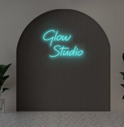 Personalized business name neon sign in ice blue color mounted on aesthetic wall.