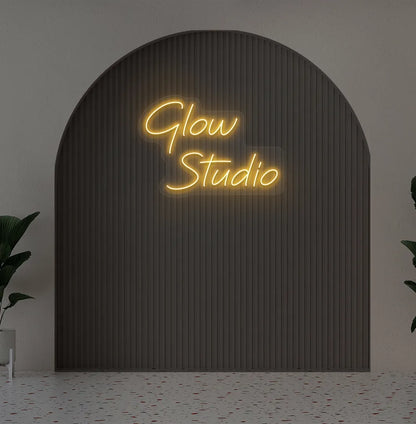 Stylish personalized business name neon sign mounted on aesthetic wall in orange color.