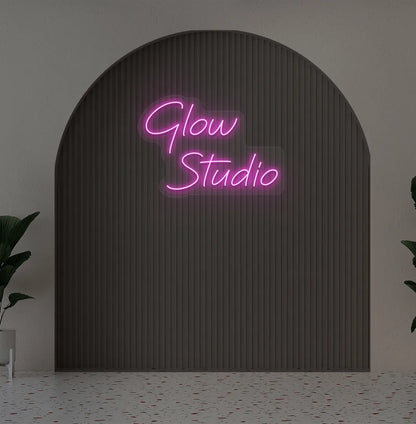 Stylish personalized business name neon sign mounted on aesthetic wall in purple color.