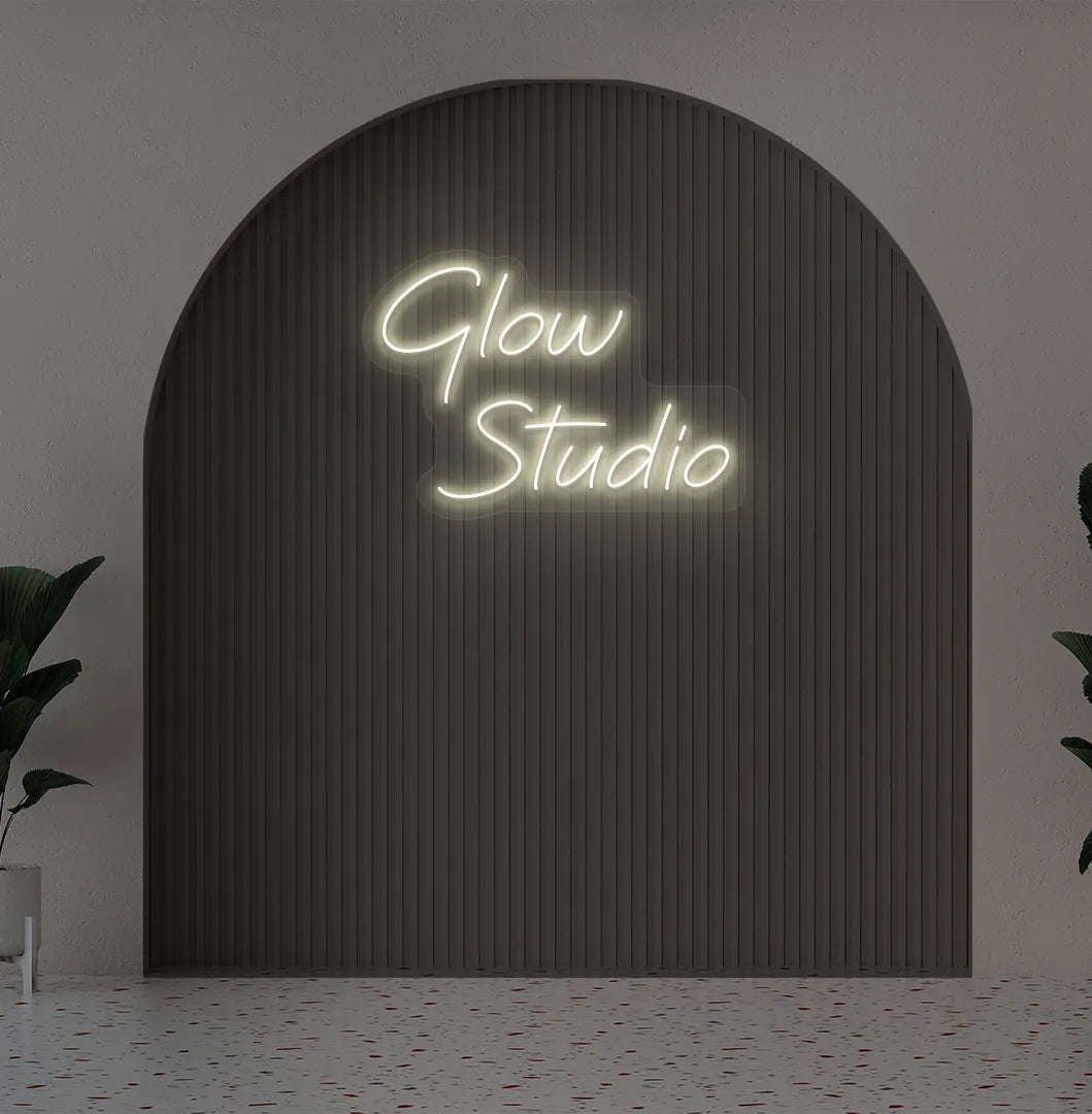 Stylish personalized business name neon sign mounted on aesthetic wall in warm white color.