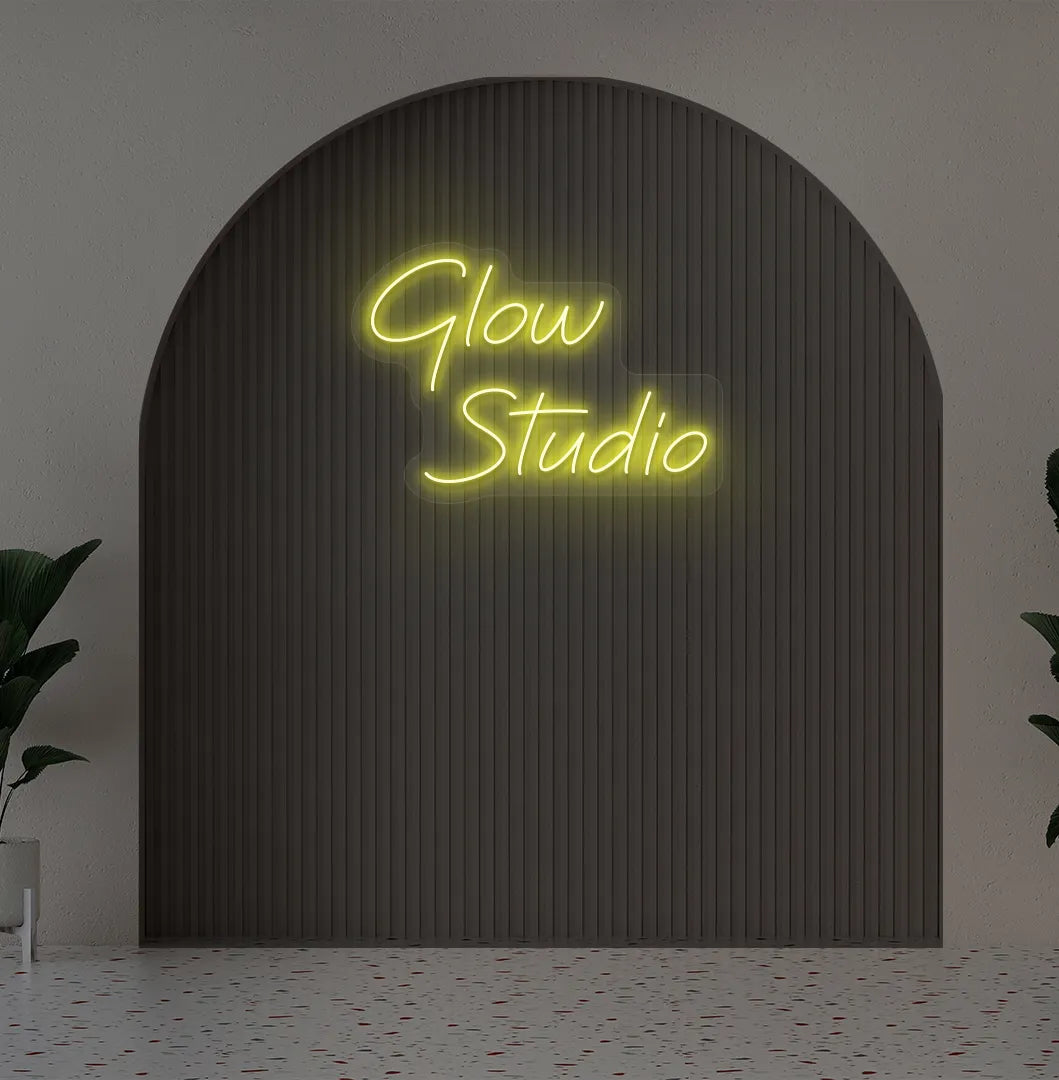 Stylish personalized business name neon sign mounted on aesthetic wall in yellow color.