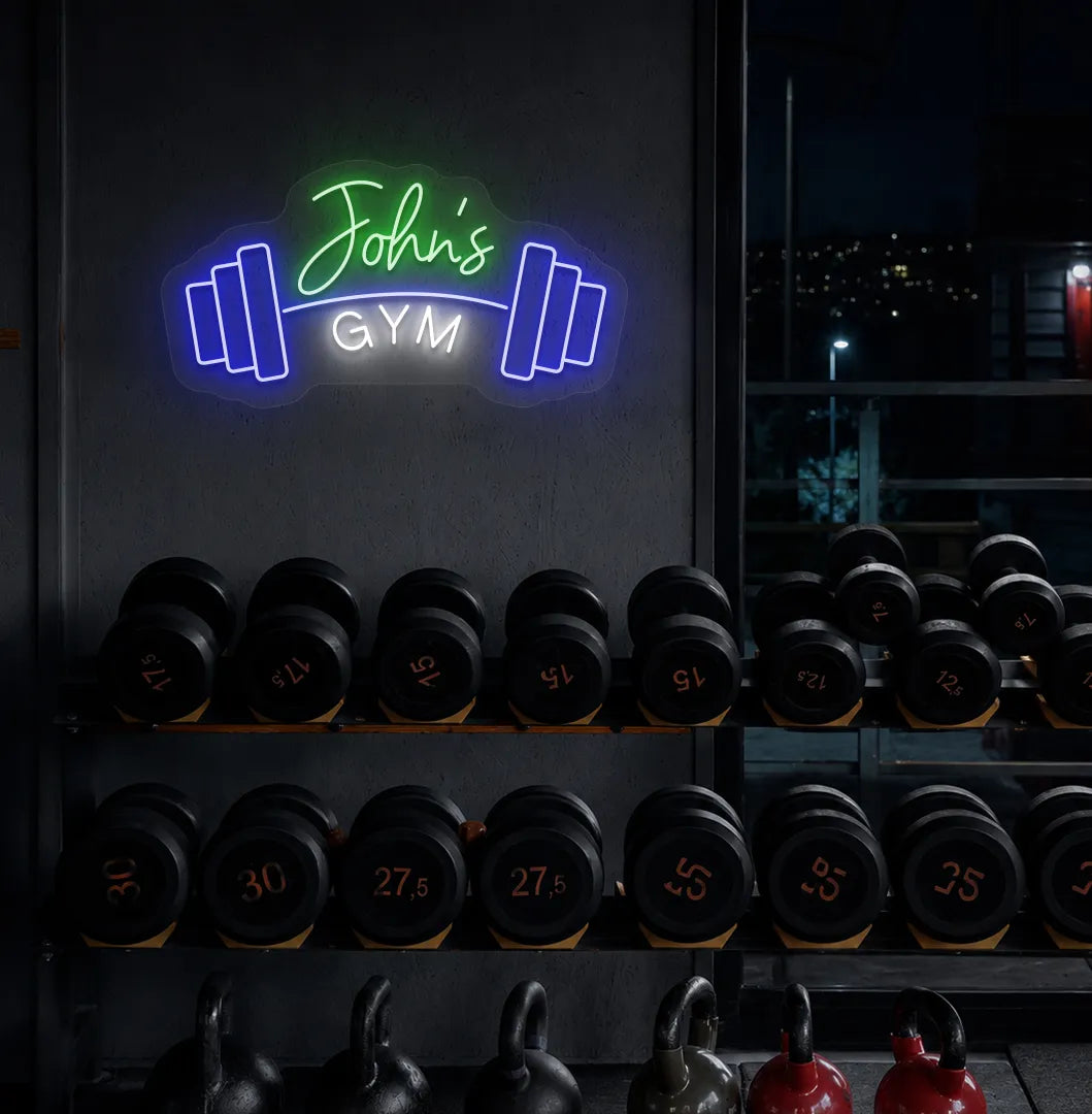 Custom GYM Name with Dumbbell LED neon sign mounted on modern fitness studio wall in green color.