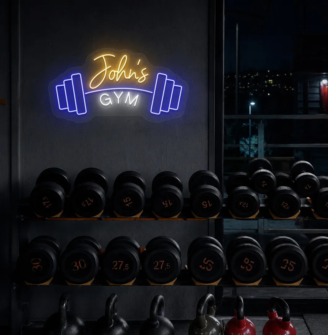 Custom GYM Name with Dumbbell LED neon sign mounted on modern fitness studio wall in orange color.