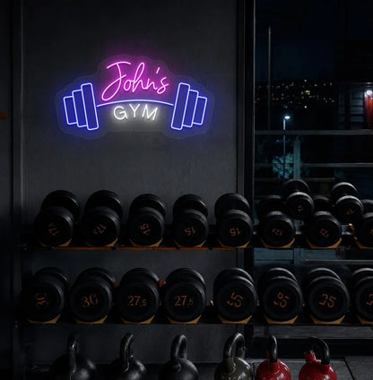 Stylish personalized gym name neon sign with dumbbell mounted on aesthetic wall in pink color.