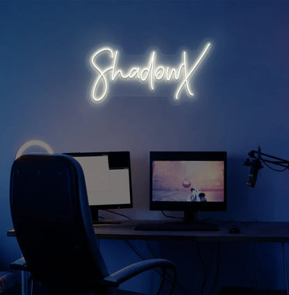 Image of a stylish personalized gamer tag neon sign mounted on decorative wall in warm white color.