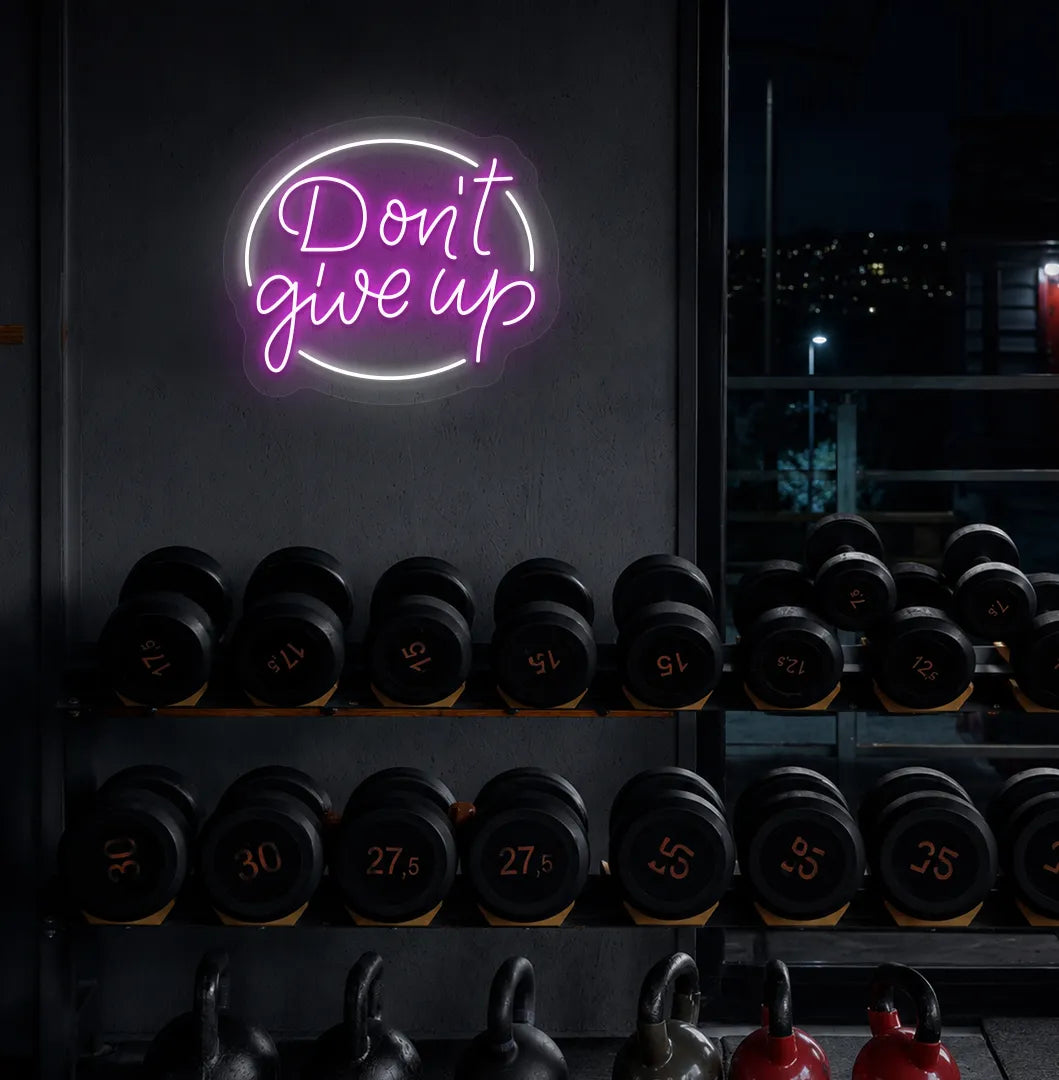 Image of an Aesthetic gym wall with "don't give up" neon sign glowing pink.