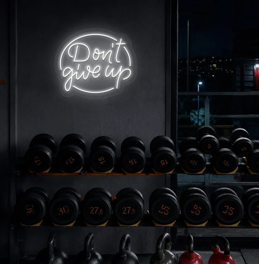 Image of an Aesthetic gym wall with "don't give up" neon sign glowing white.