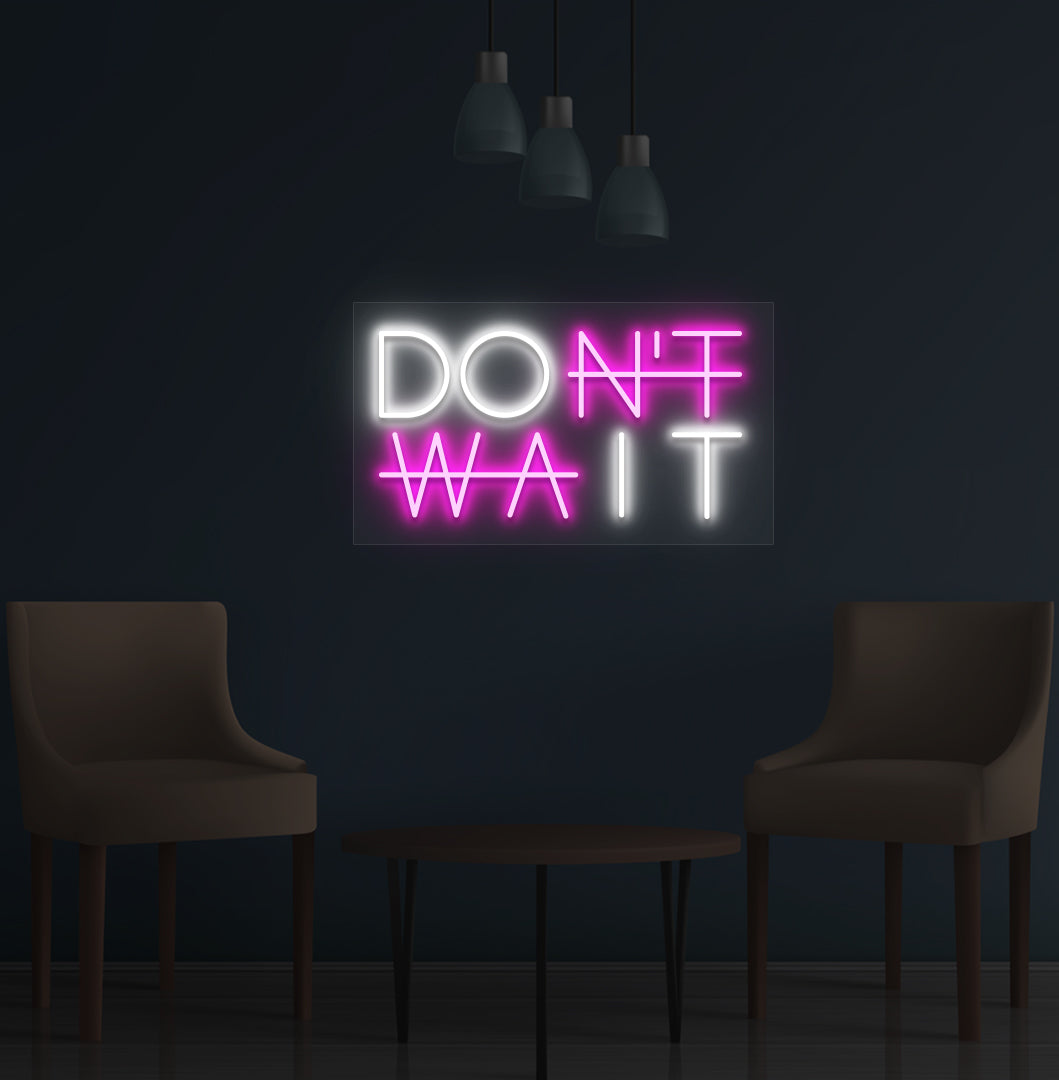Image of a motivational "Don't Wait" LED neon sign mounted on a wall in pink color.