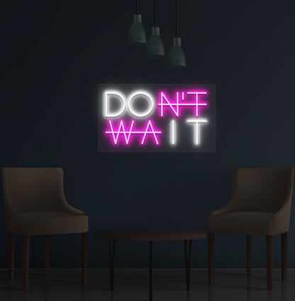 Image of a motivational "Don't Wait" LED neon sign mounted on a wall in pink color.