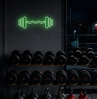 Trendy dumbbell neon sign in green mounted on fitness wall.