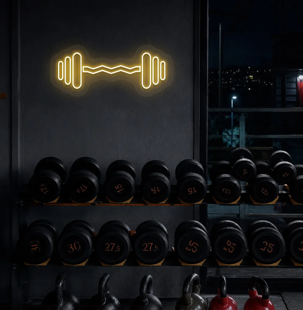 Trendy dumbbell neon sign in orange mounted on fitness wall.