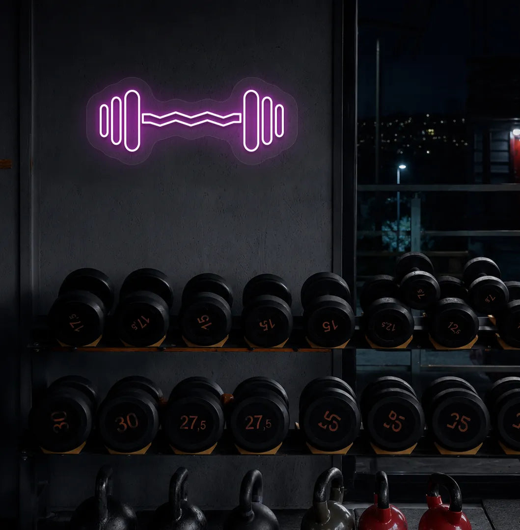 Trendy dumbbell neon sign in purple mounted on fitness wall.