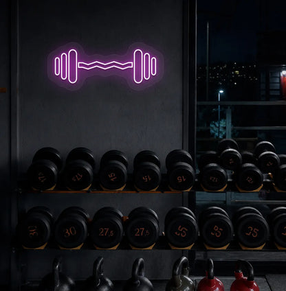 Trendy dumbbell neon sign in purple mounted on fitness wall.