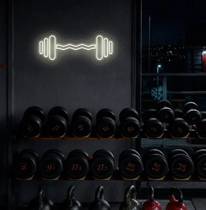 Trendy dumbbell neon sign in warm white mounted on fitness wall.