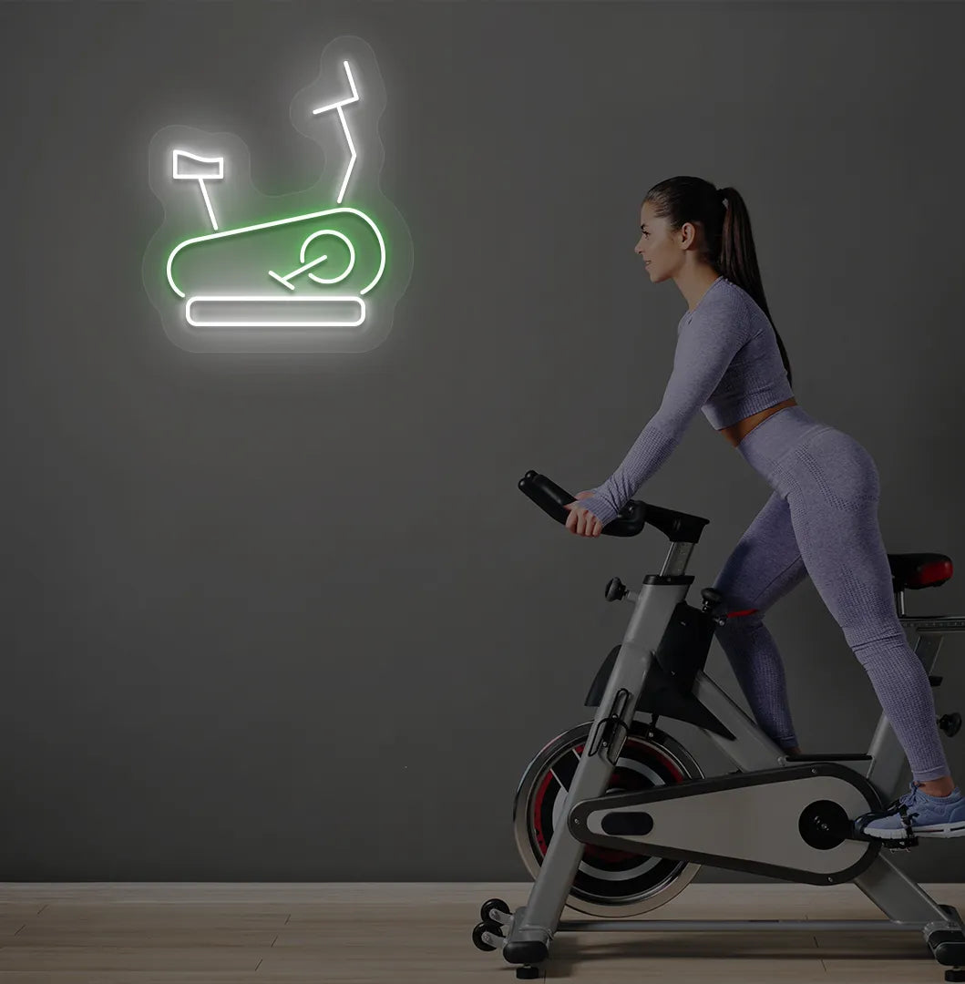 Trendy exercise cycle neon sign in green mounted on fitness wall.