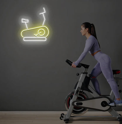 Trendy exercise cycle neon sign in yellow mounted on fitness wall.