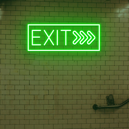 Image of an exit LED neon sign glowing on a brick-patterned wall in green.