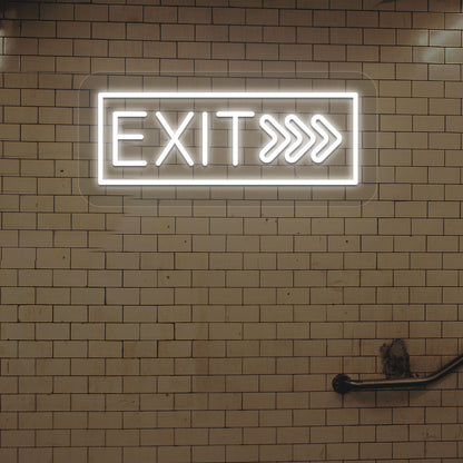 Image of an exit LED neon sign glowing on a brick-patterned wall in white.