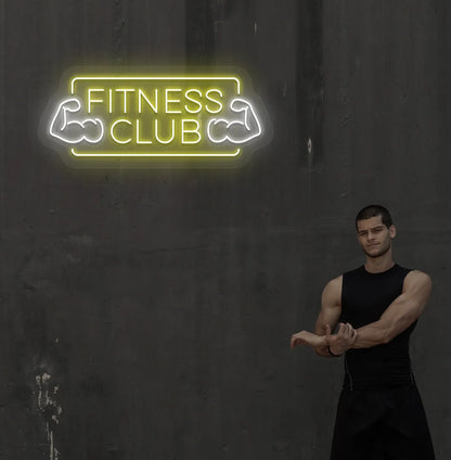 Stylish fitness club neon sign in yellow mounted on gym wall.
