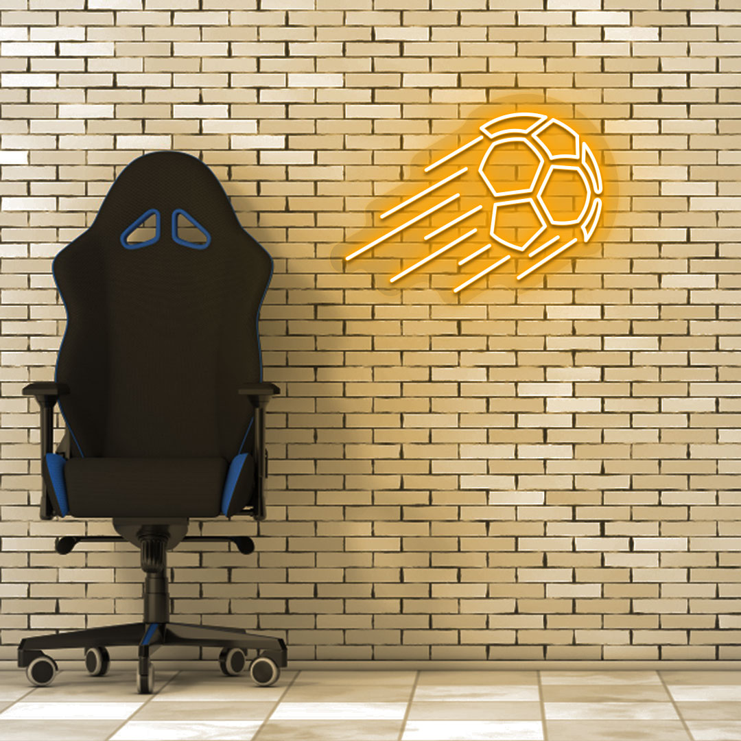 Game room decor with an orange flying football neon sign on a brick wall and a chair.