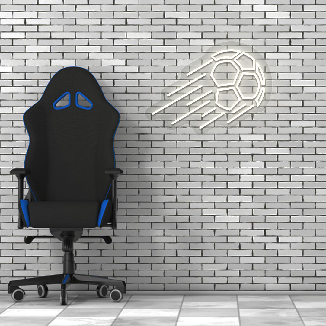 A sports warm white LED flying football neon sign glows on a brick wall with a chair. Perfect for game rooms, sports setups, and streamers.