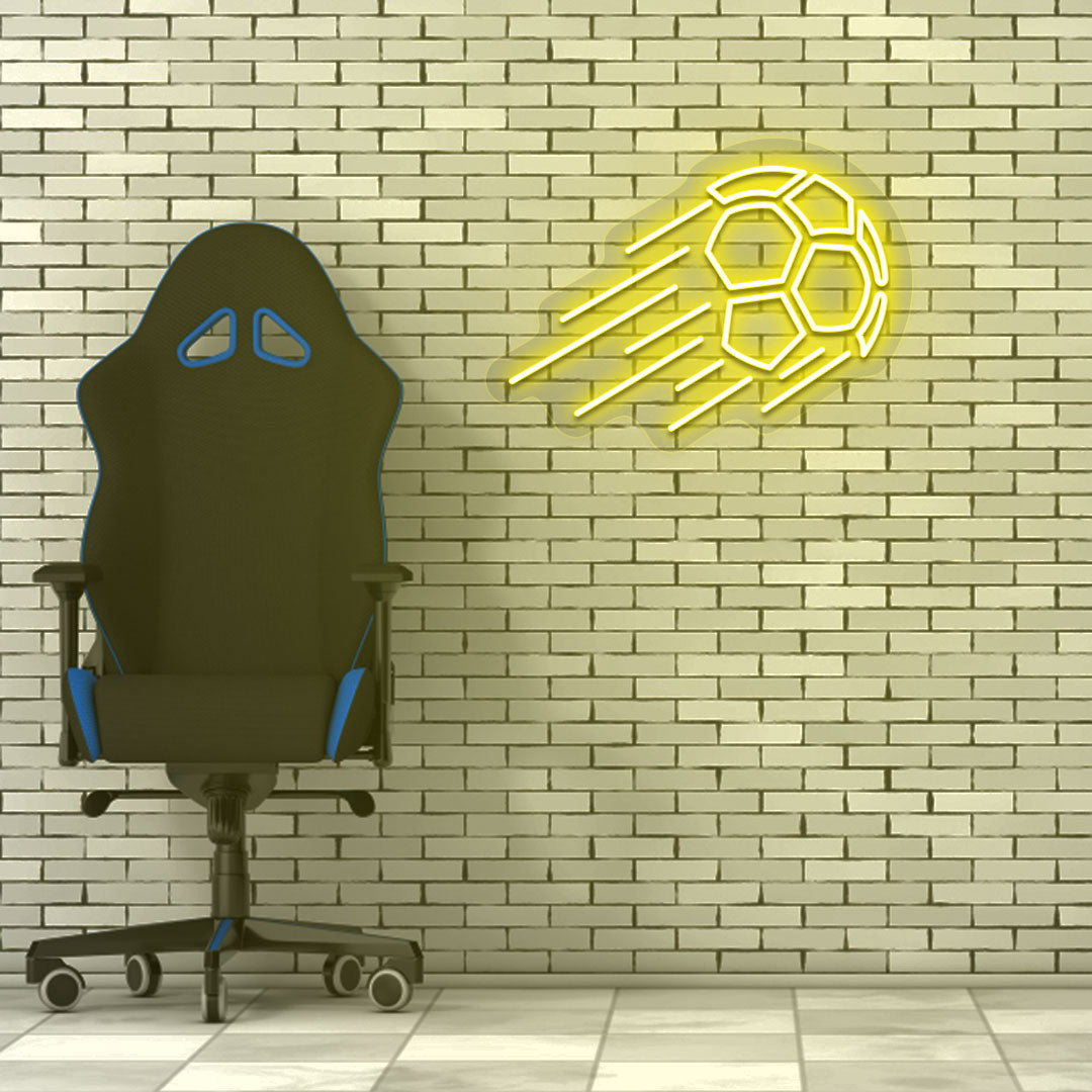 A sports yellow LED flying football neon sign glows on a brick wall with a chair. Perfect for game rooms, sports setups, and streamers.