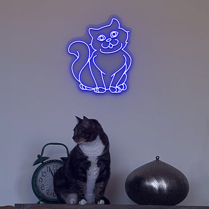 Wall decor with a blue LED cat neon sign glowing on the wall and a cute cat below.