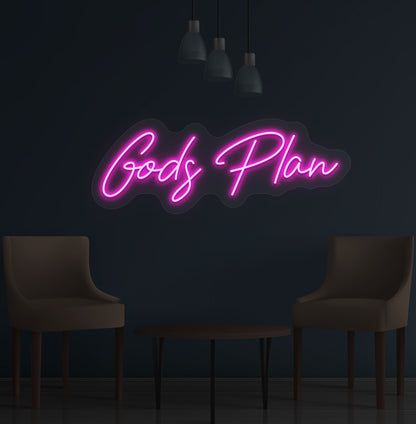 Image of an inspirational "God's Plan" LED neon sign glowing on a wall in pink color.